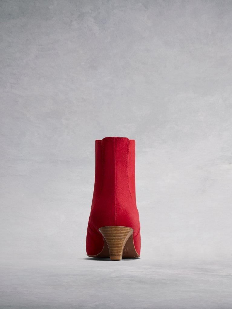 This red ankle boot features an elegant slim, square shaped, low Italian heel.