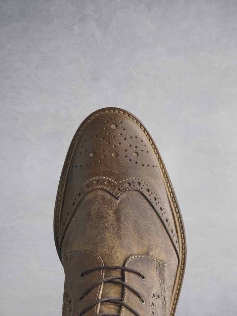 With stylish tan leather brogue detailing over the classic round toe shape.