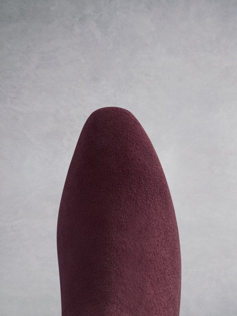 The burgundy boot has a chisel toe shape that matches the heel shape.