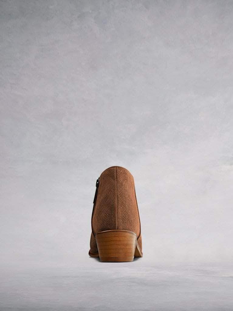 This low cut tan ankle boot has a flattering curved topline. 