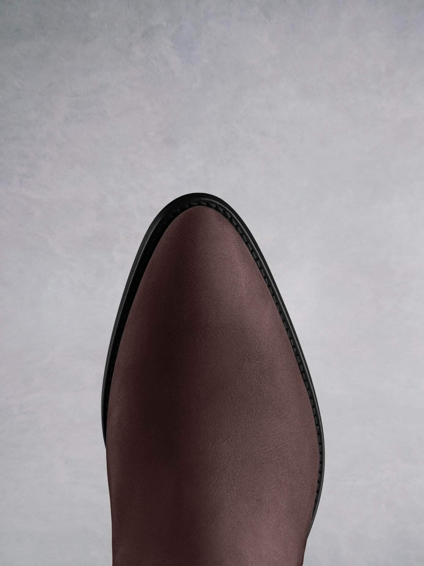 This burgundy ankle boot features a western style pointed toe shape. 