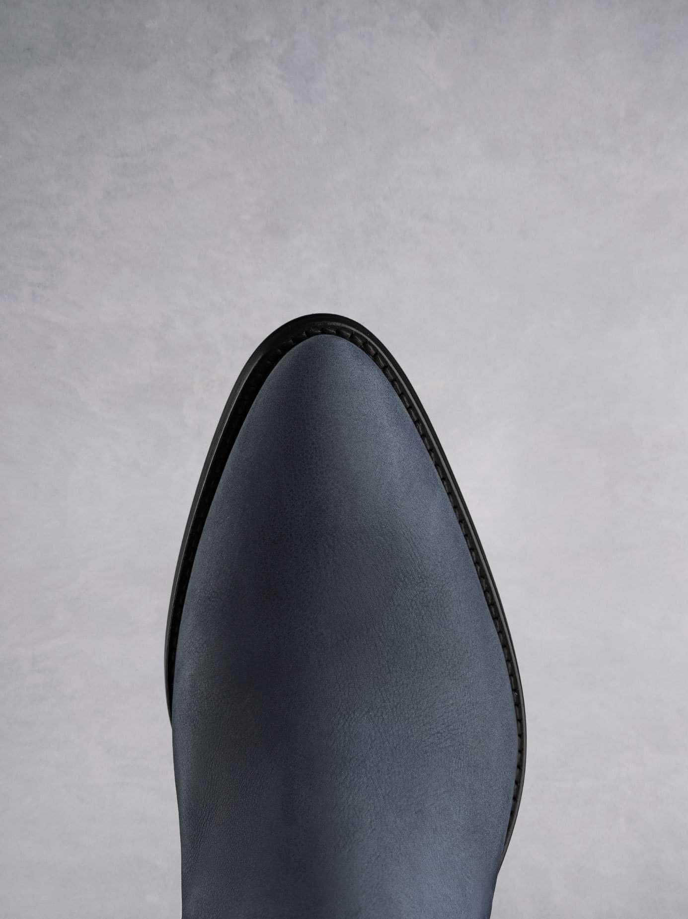 This petrol blue ankle boot features a western style pointed toe shape. 