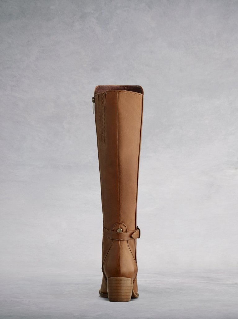 The tan back features a stacked wooden heel, ankle strap and metal stud.