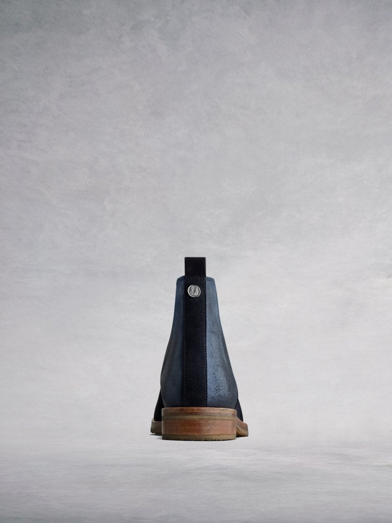 The back features a narrow navy suede panel and pull-tab. 