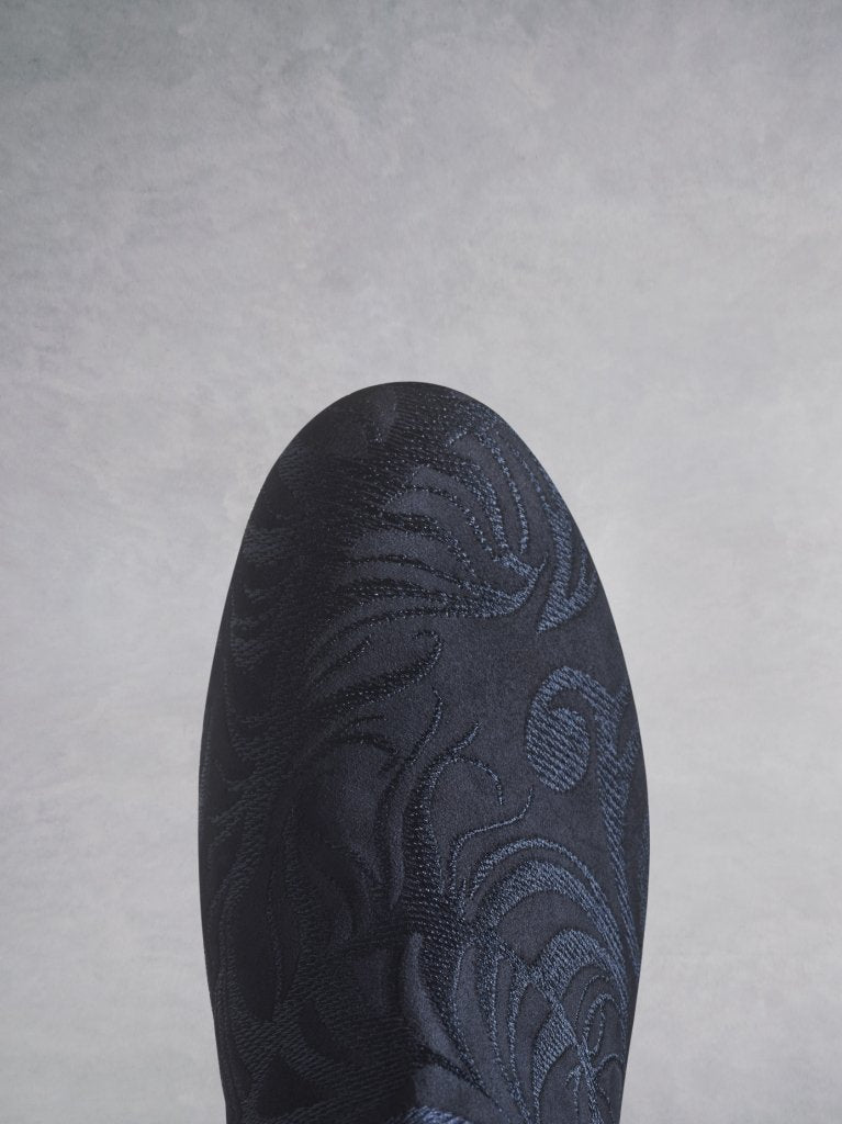 The round navy suede toe is covered in tonal embroidery. 