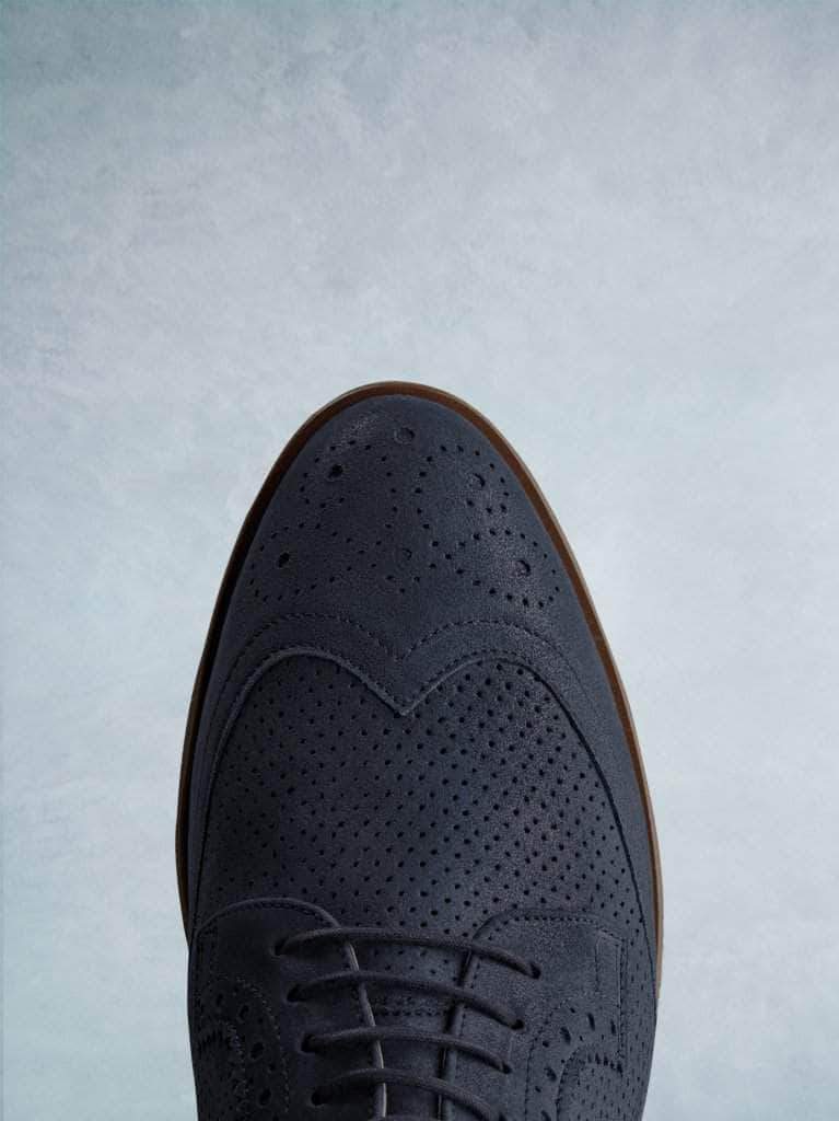 Featuring a stylish navy almond toe complemented by brogue detailing.