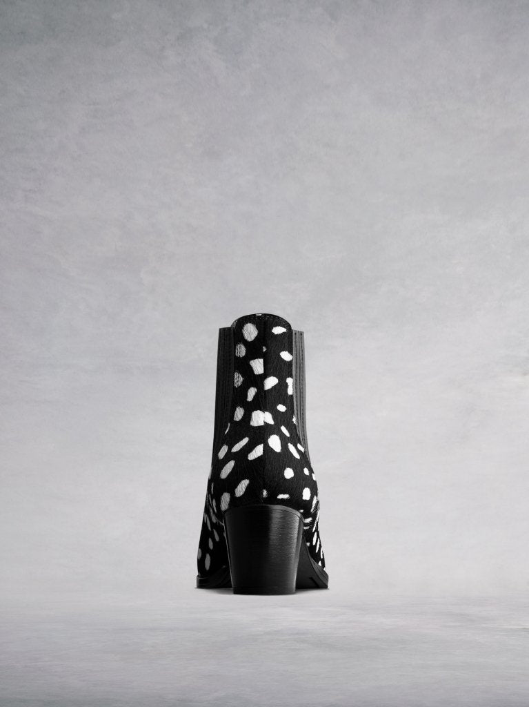 The hair leather back has elegant stitching and a stacked Cuban heel.