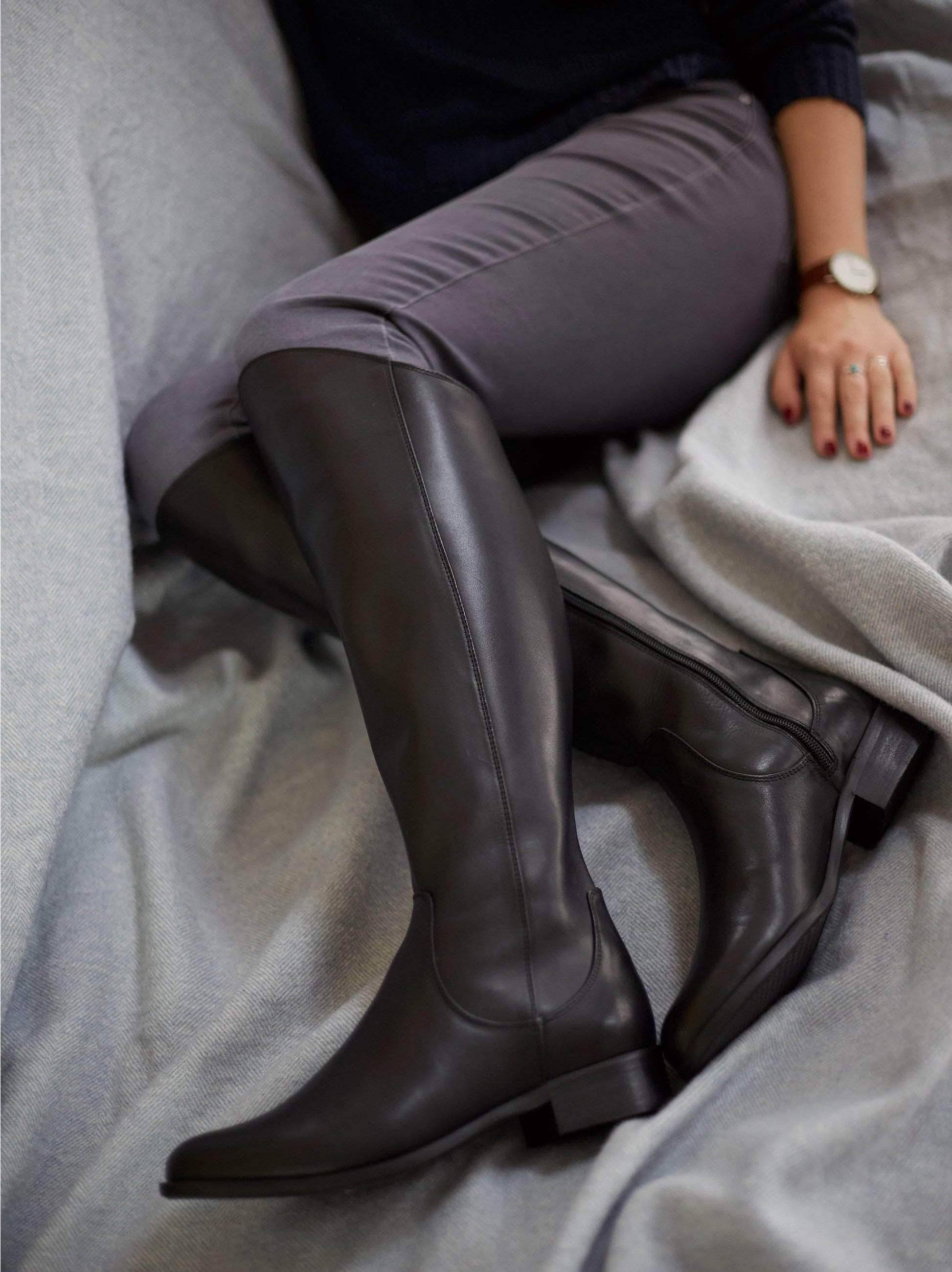 Huntsman, a knee high, fashion riding boot in black leather with an asymmetric top line.
