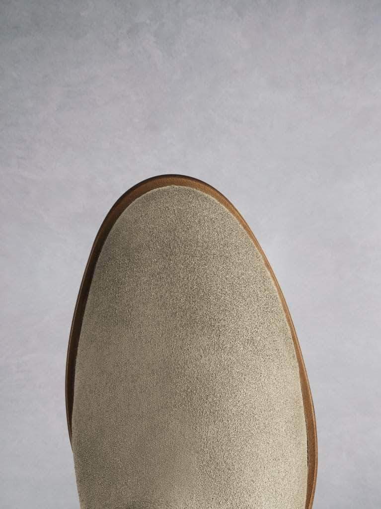 The taupe suede boot has a smooth round toe shape.