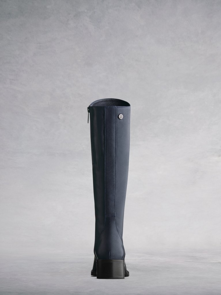 This navy boot has a smooth elegant back panel and a shorter knee high cut. 
