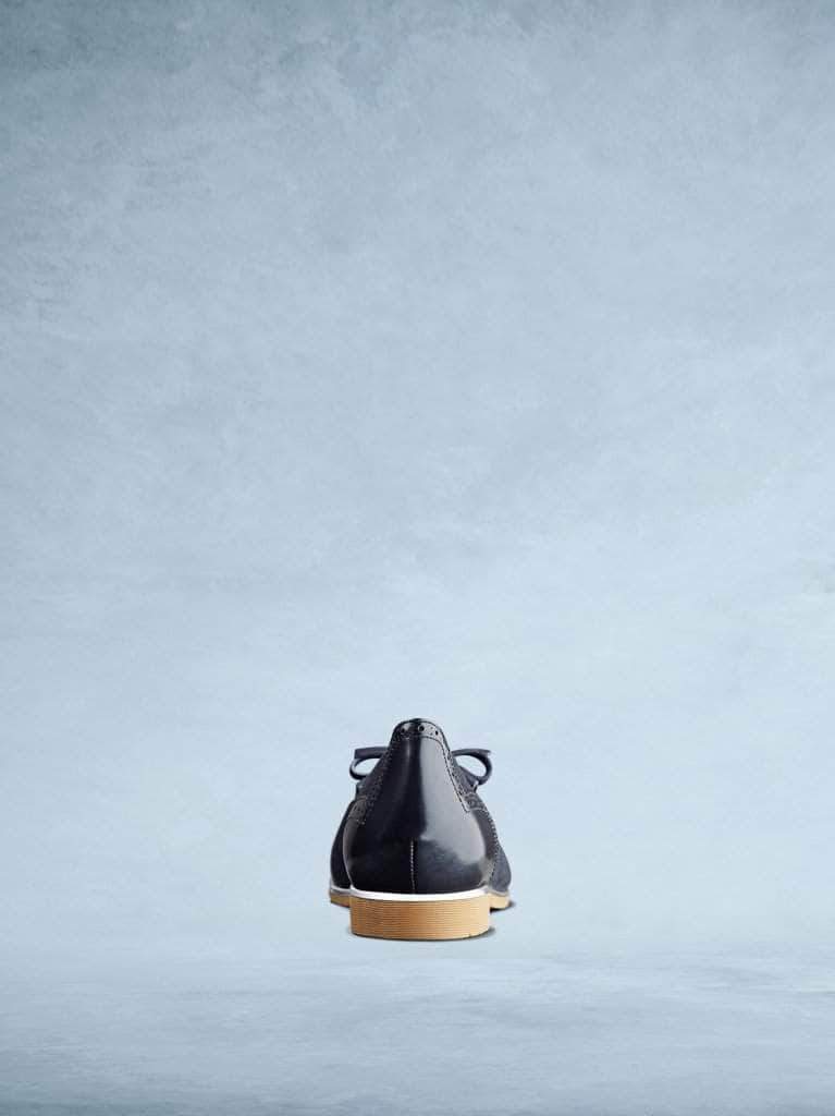 The navy back features subtle brogue detailing and a contrasting metallic trim. 