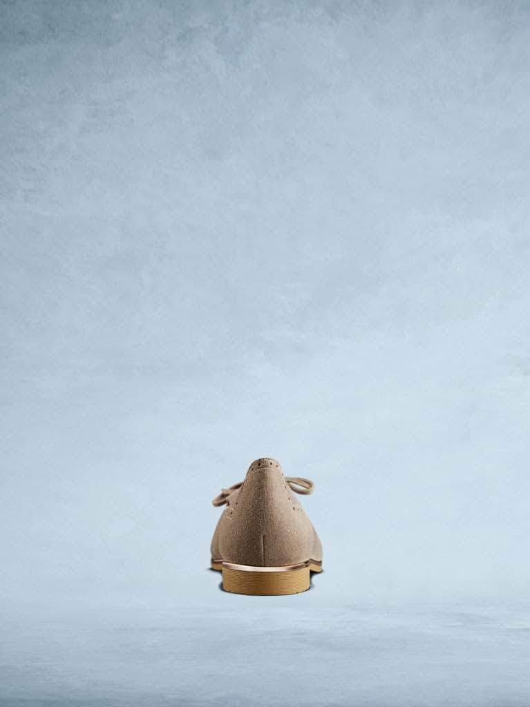 Lamorna taupe suede features subtle brogue detailing and a contrasting metallic trim. 
