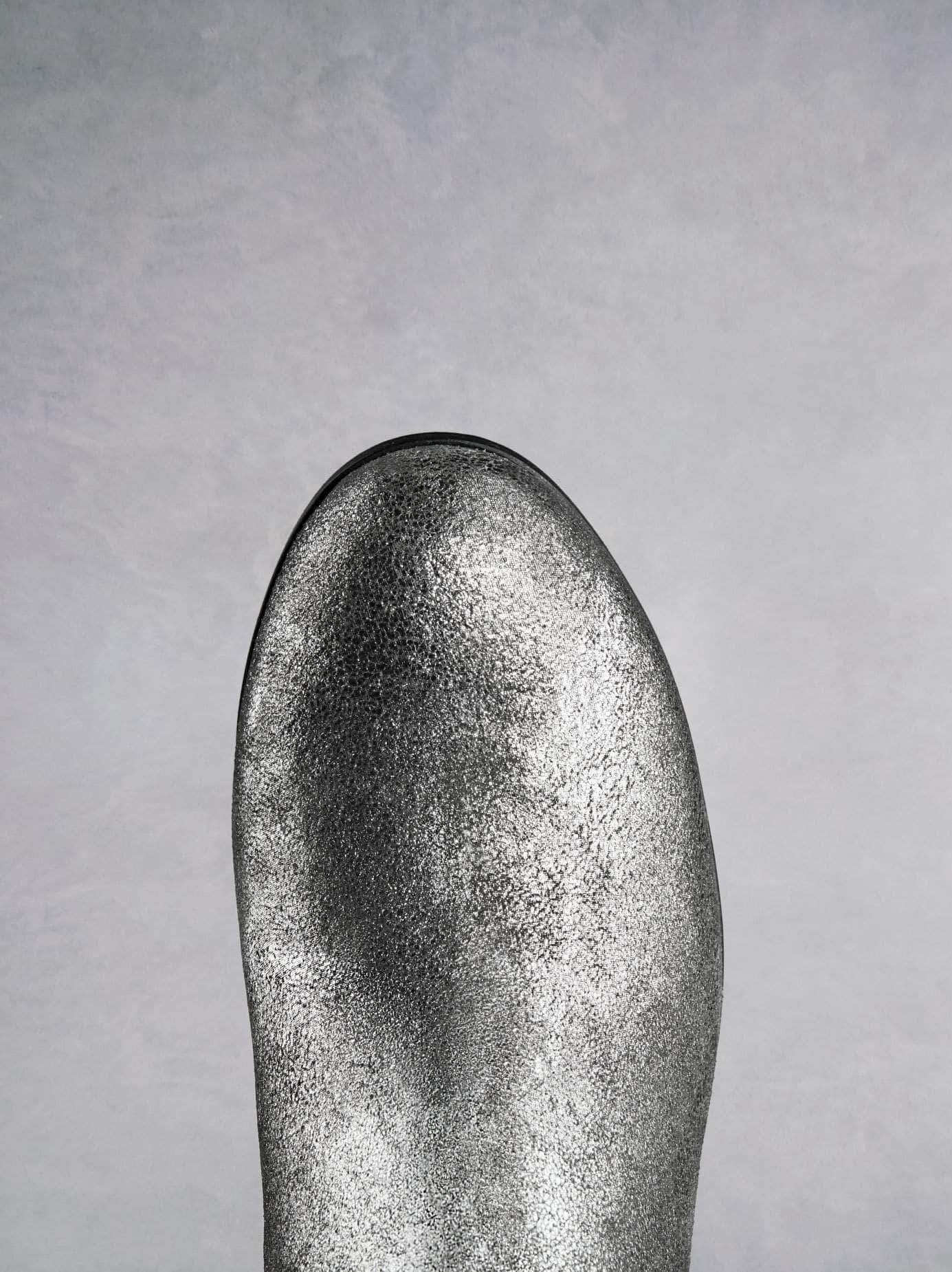 This metallic silver ankle boot has a comfortable round toe shape.