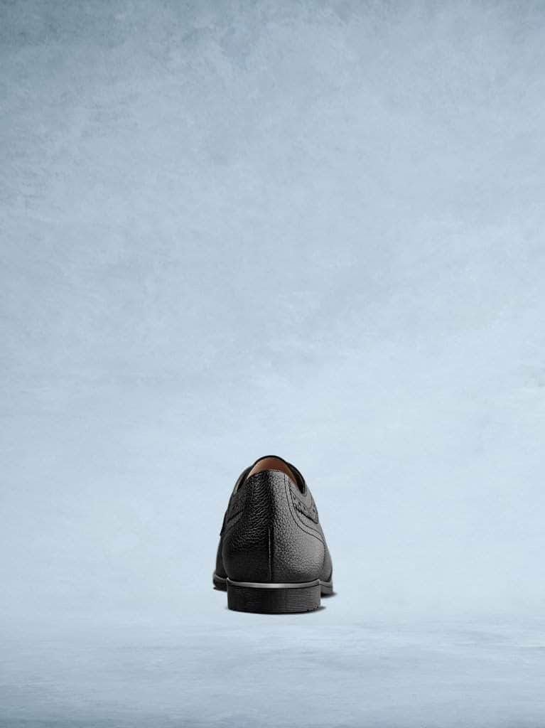 Mullion in black textured leather features a contrasting brown sole. 