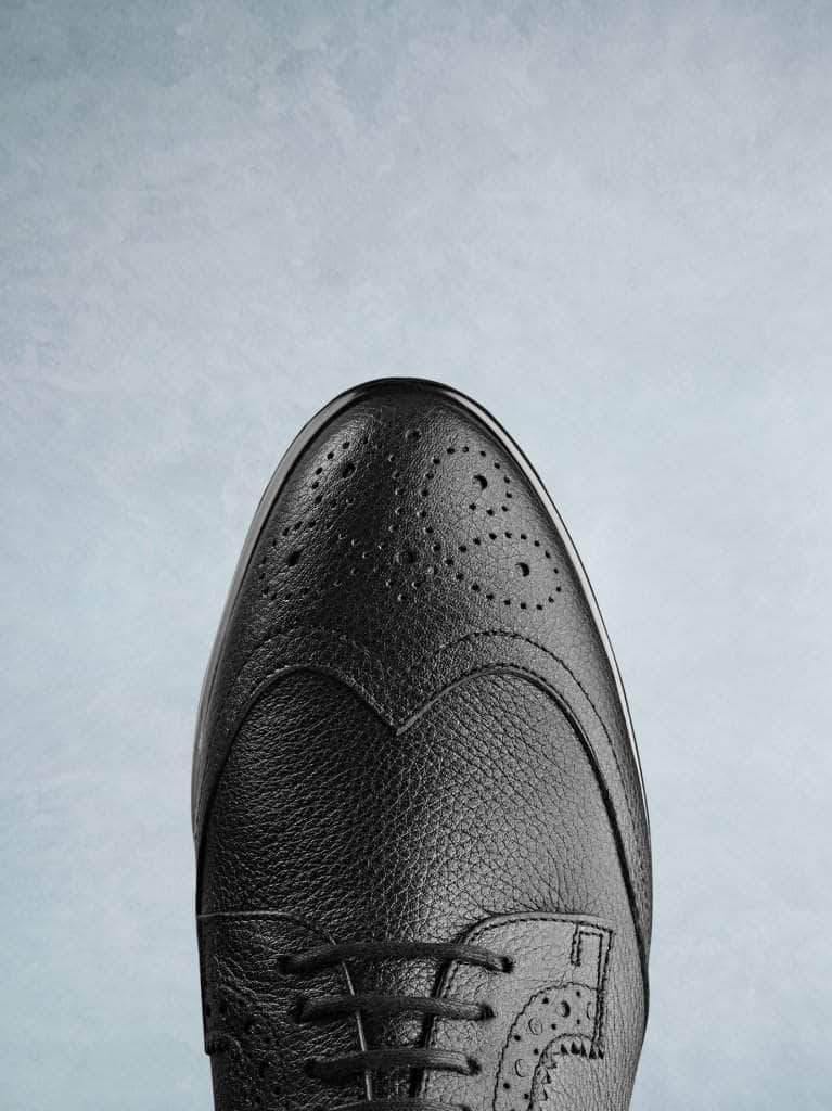 Featuring a brogue detailed elegant black leather almond toe.