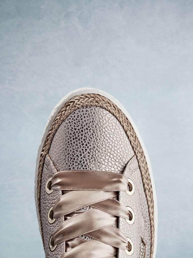 This rose gold trainer has a smooth round toe highlighted by the lace trim.