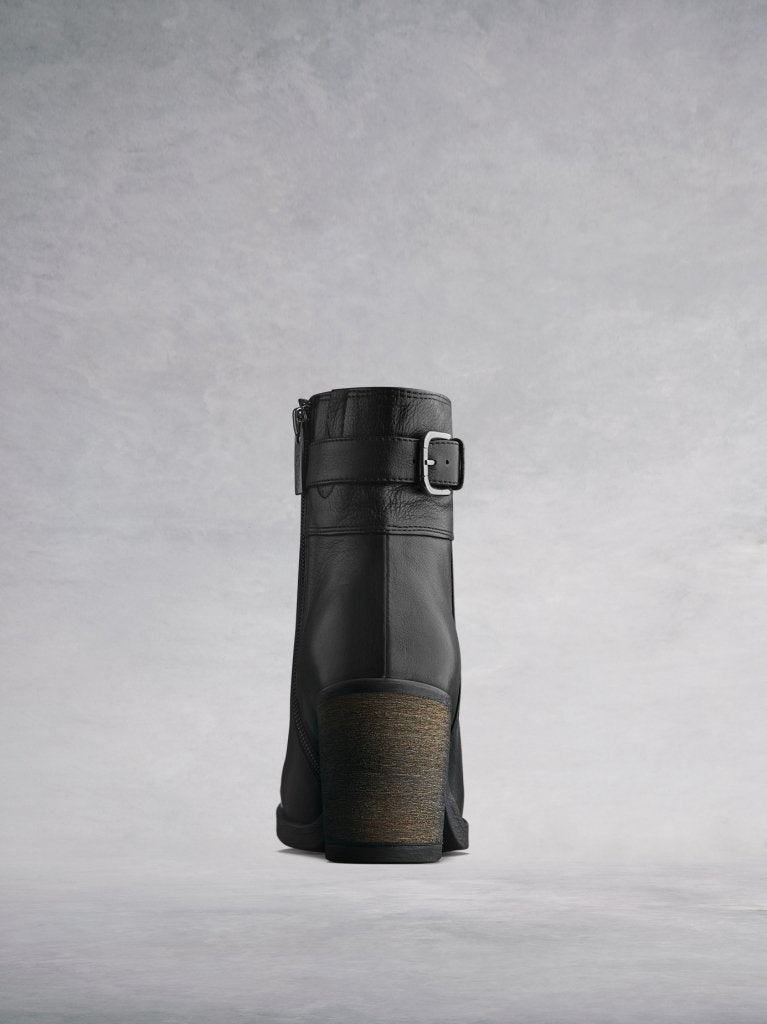 The black boot has a stylish stacked leather veneer around the block heel. 