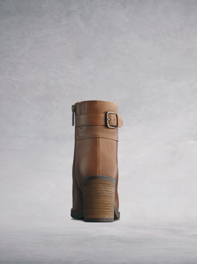 The tan boot has a stylish stacked leather veneer around the block heel. 