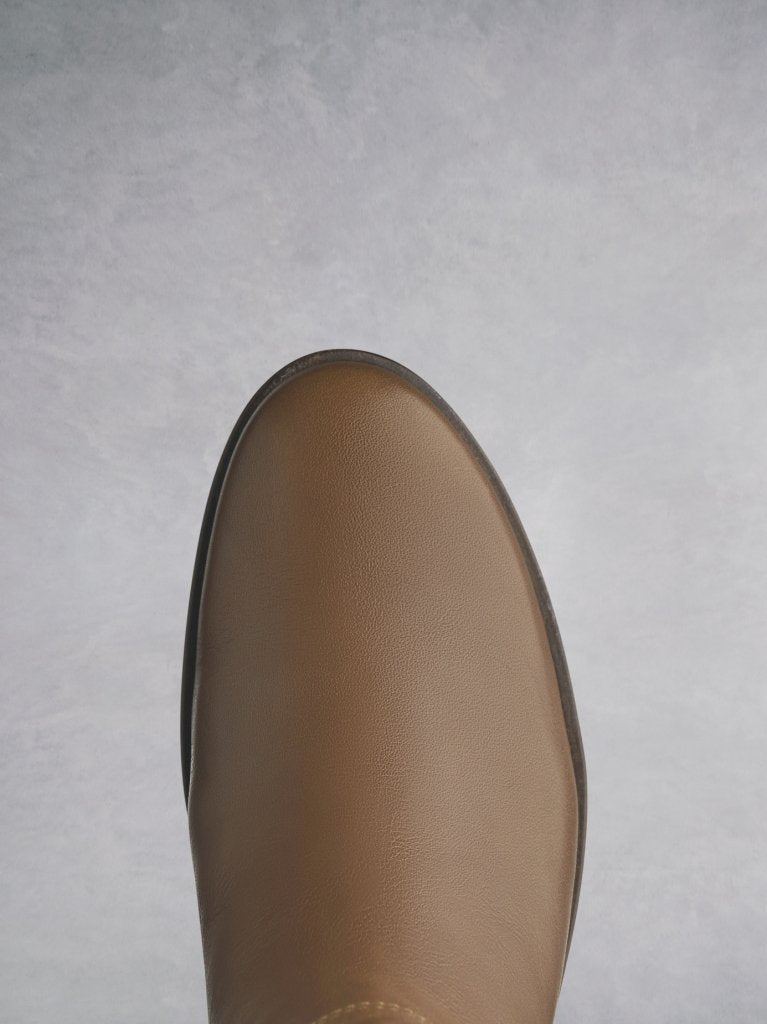 Orpheus in tan, with a round toe complementing the shape of the block heel. 