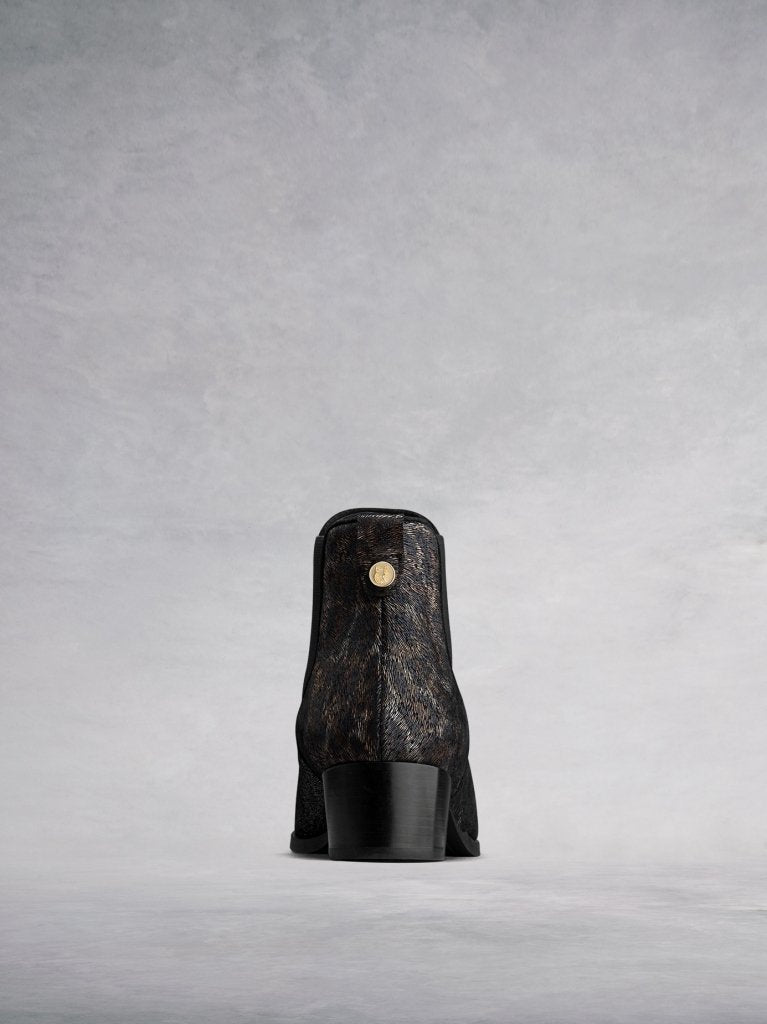 The back features the stacked block heel and a signature wolf stud. 