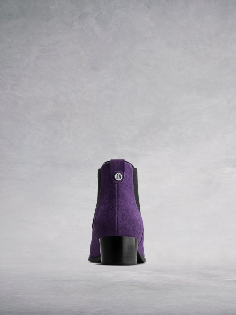 The purple back features a stacked block heel and signature wolf stud. 
