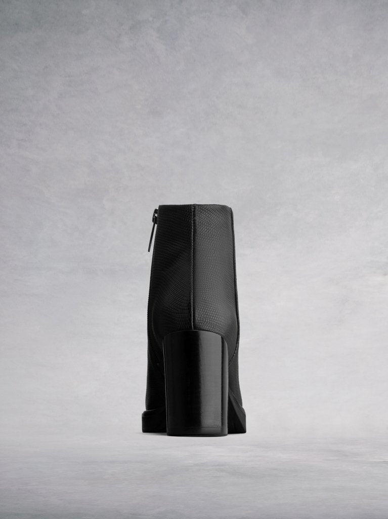 The black ankle boot is complemented by a polished stacked block heel.