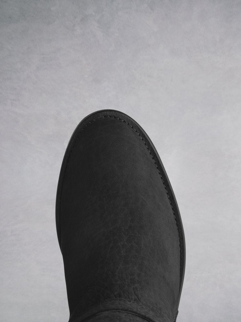 This black ankle boot has a comfortable round toe with shearling lining. 