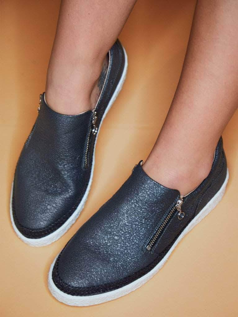 This slate grey zip fastened trainer has a textured white sole. 